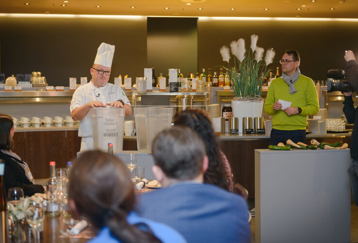 Cooking demonstration at the ATLANTIC Hotel Sail City, Bremerhaven, with guests and chef in a modern ambience.