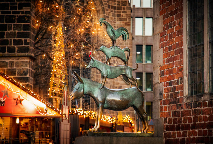 Statue of the Bremen Town Musicians with festive lighting background