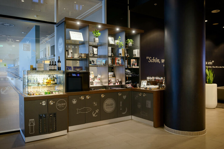 Hotel store with minibar and shelves filled with drinks, souvenirs and plants in the ATLANTIC Hotel Sail City.