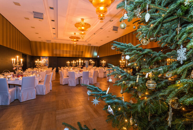 Festlich dekorierter Bankettsaal im ATLANTIC Grand Hotel Bremen mit Kerzenleuchtern und geschmücktem Weihnachtsbaum.