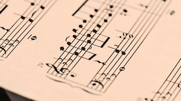 Notenblatt liegt auf Klaviertasten, symbolisiert musikalische Eleganz im ATLANTIC Grand Hotel Travemünde.