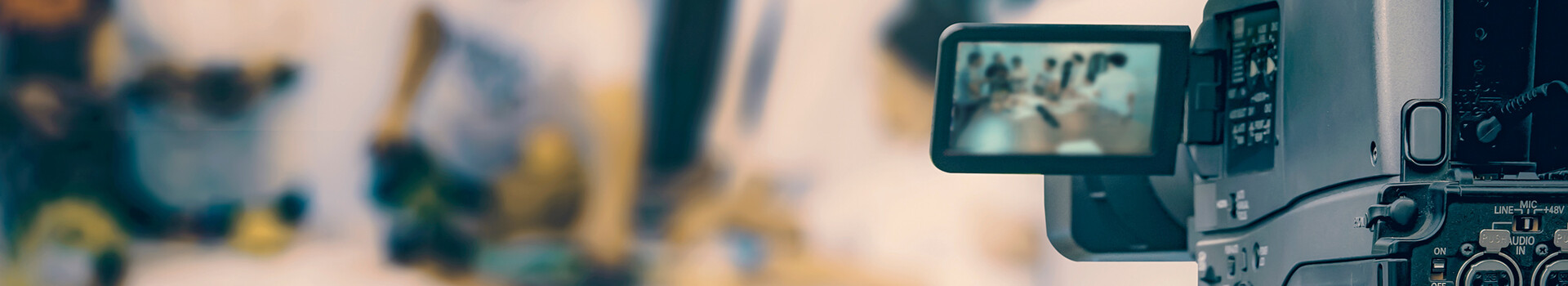 ATLANTIC Hybrid Kamera im Vordergrund filmt unscharfe Gruppe von Menschen bei einem Meeting.