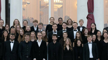 Eine große Gruppe festlich gekleideter Menschen steht vor dem ATLANTIC Grand Hotel Travemünde.