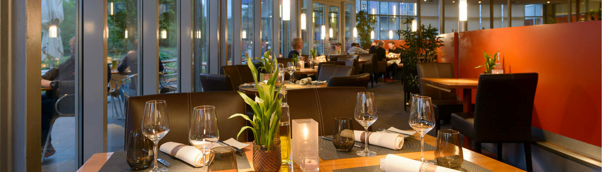 Restaurant CAMPUS des ATLANTIC Hotel Universum in Bremen Modernes Hotelrestaurant mit gedeckten Tischen, großen Fenstern und stimmungsvoller Beleuchtung im ATLANTIC Hotel Universum.