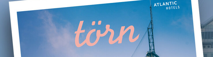 Magazine title "törn" in front of blue sky, showing modern building and logo of Atlantic Hotels.