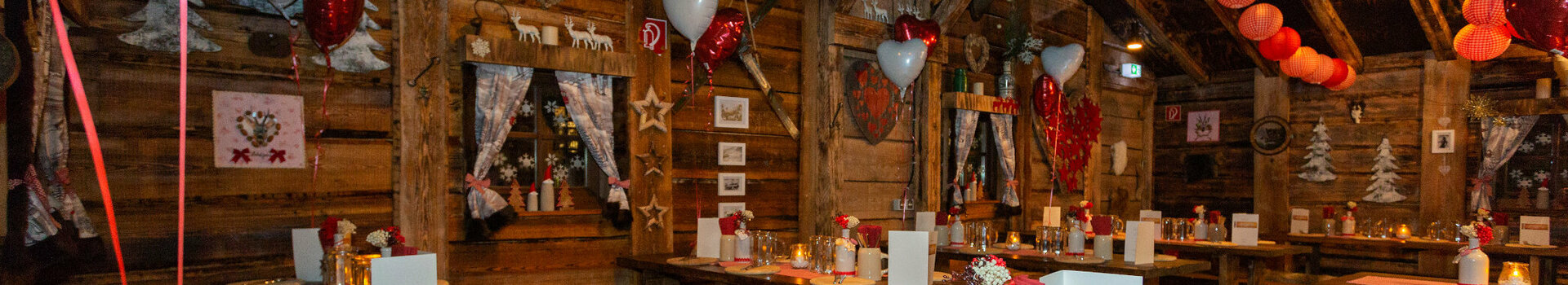 Almhütte-Feier im ATLANTIC Grand Hotel Bremen Gemütliche, rustikale Stube im ATLANTIC Grand Hotel Bremen mit Holztischen, rot-weißer Deko und warmem Licht.