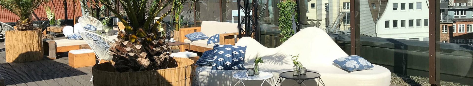 Roof terrace at the ATLANTIC Grand Hotel Bremen Roof terrace of the ATLANTIC Grand Hotel Bremen with palm trees, seating and a view of Bremen's cathedral towers.