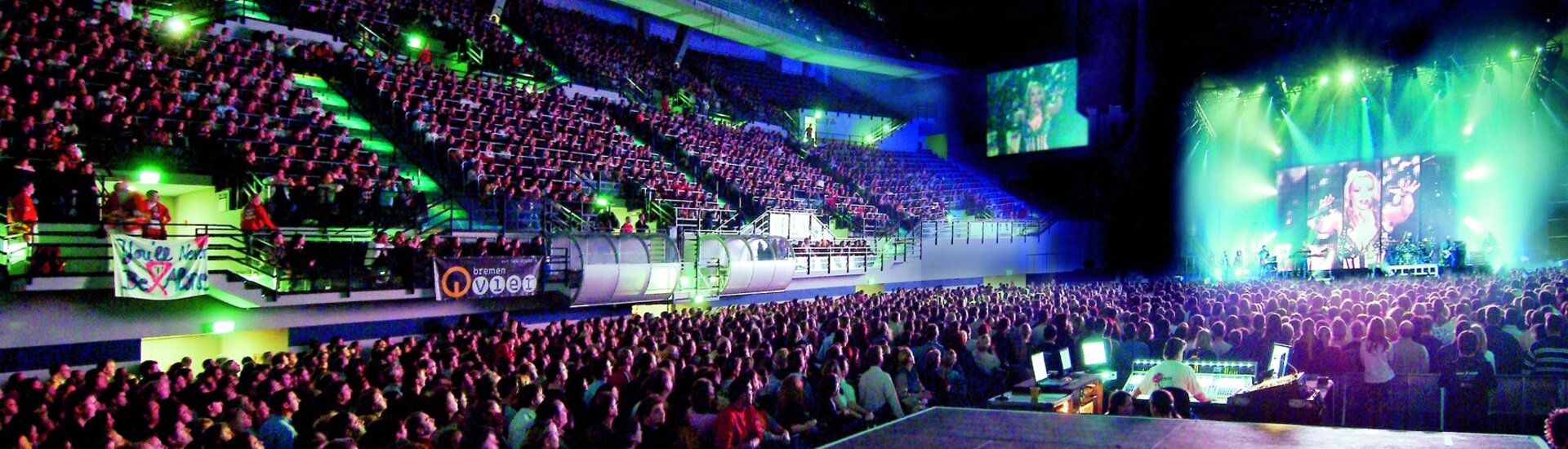 The ÖVB Arena during an event Large, well-attended concert arena with stage, colorful lights and sound mixer in the foreground.