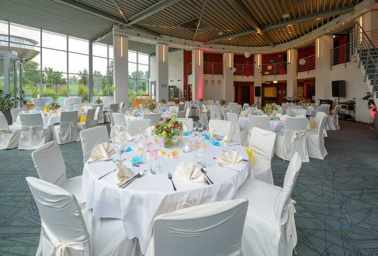 Eleganter Bankettsaal im ATLANTIC Hotel Universum, Bremen, mit festlich gedeckten Tischen und Blumendekoration.
