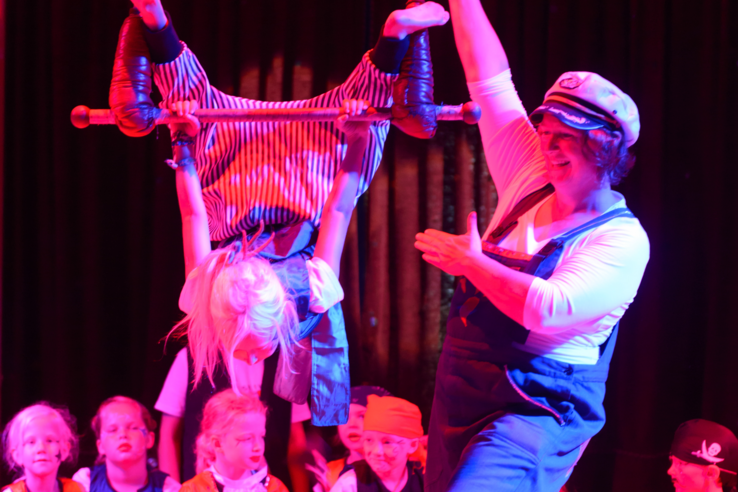 Kinder bei Zirkusvorstellung in Lemwerder, Bremen, mit Artistin auf Trapez, umgeben von applaudierendem Publikum.