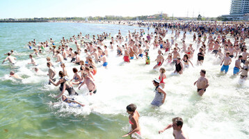 Menschenmenge läuft ins Meer, Neujahrs Anbaden am  Strand von Travemünde.