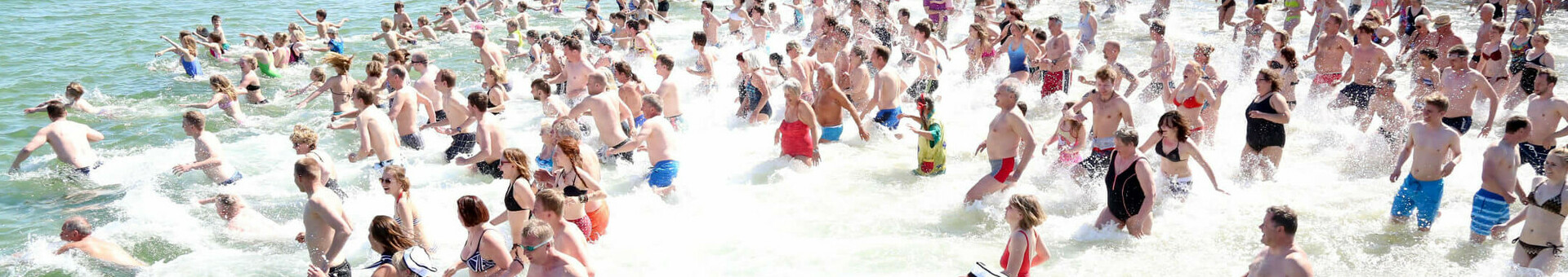 Anbaden in Travemünde Menschenmenge läuft ins Meer, Neujahrs Anbaden am  Strand von Travemünde.