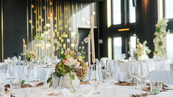 Elegant restaurant in the ATLANTIC Hotel Heidelberg, festively laid tables with flower arrangements and candles.