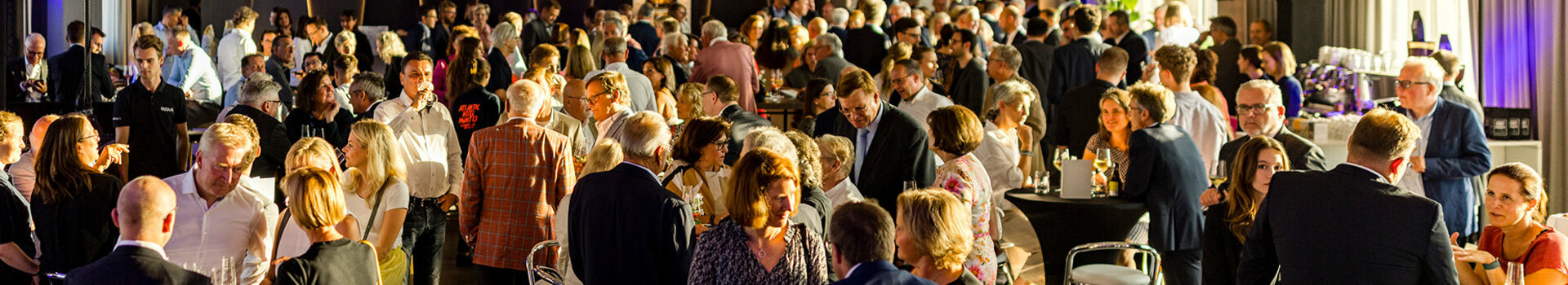 Große Menschenmenge bei einer Veranstaltung im ATLANTIC Hotel Münster, in einem elegant beleuchteten Raum.