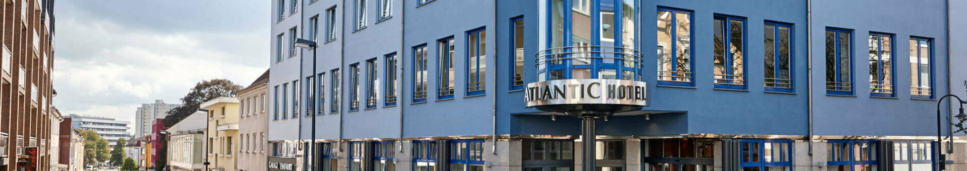 ATLANTIC Hotel Vegesack Außenaufnahmen Exterior view of the ATLANTIC Hotel Vegesack in Bremen, modern building with blue glass façade and street scene.