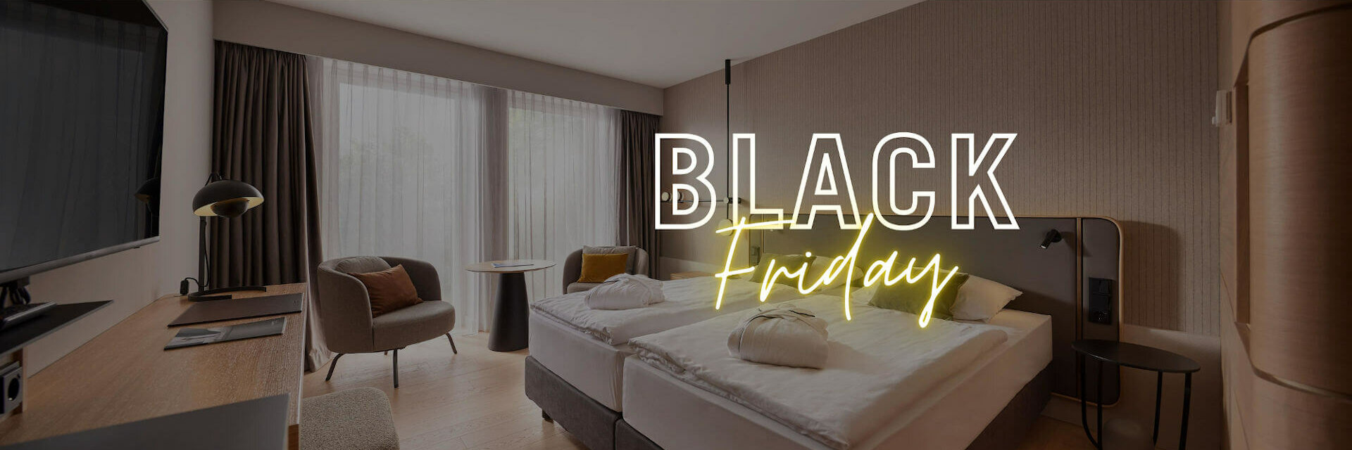 Modern hotel room with double bed, desk, armchair and large window, overlaid with "Black Friday" text.