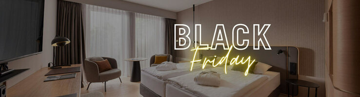 Modern hotel room with double bed, desk, armchair and large window, overlaid with "Black Friday" text.