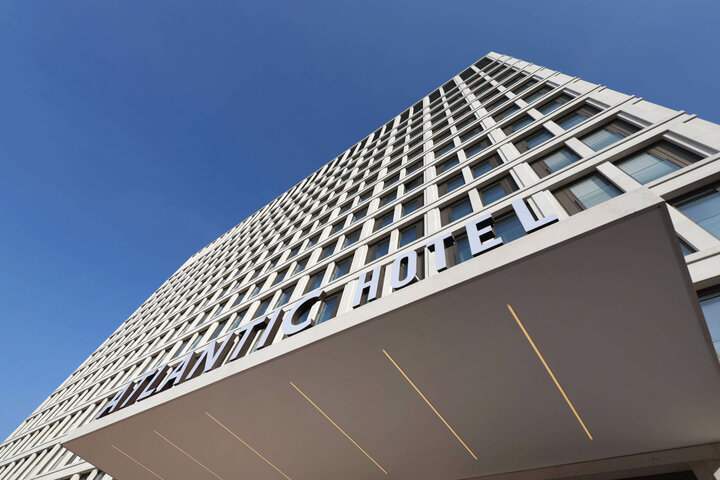 Fassade und Hoteleingang vom ATLANTIC Hotel Heidelberg Moderne Fassade des ATLANTIC Hotel Heidelberg mit blauem Himmel im Hintergrund.