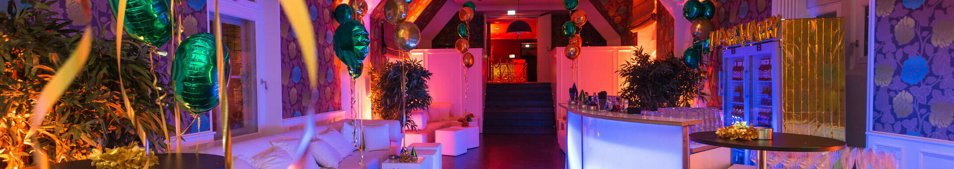 Festively decorated event room at the ATLANTIC Grand Hotel Bremen with colorful lights and balloons.