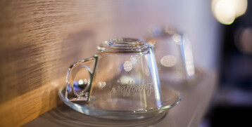 Zwei umgedrehte Glastassen auf einem Tablett, sanft beleuchtet, im ATLANTIC Hotel Airport Bremen.