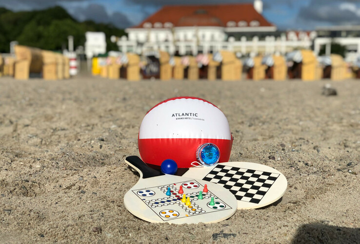 Strandspielzeug vor dem ATLANTIC Grand Hotel Travemünde: Strandball, Spielbretter und Strandkörbe im Hintergrund.