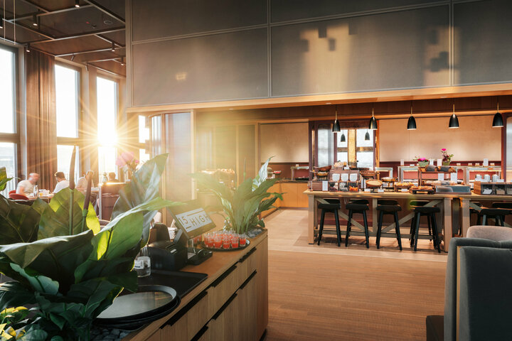 Ansicht des Frühstücksbuffets und grüner Bepflanzung im Restaurant