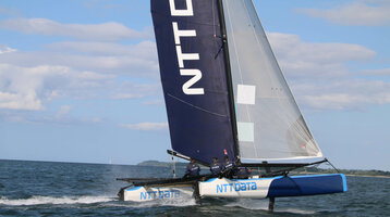 Segelkatamaran auf der Ostsee, blauer Himmel, Crew in Aktion, nahe ATLANTIC Grand Hotel Travemünde.