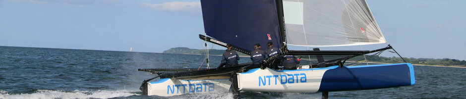 Segelkatamaran auf der Ostsee, blauer Himmel, Crew in Aktion, nahe ATLANTIC Grand Hotel Travemünde.