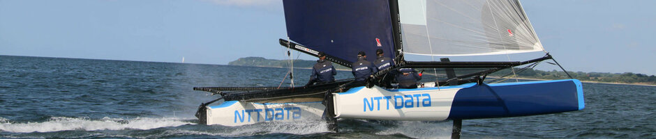 Sailing catamaran on the Baltic Sea, blue sky, crew in action, near ATLANTIC Grand Hotel Travemünde.