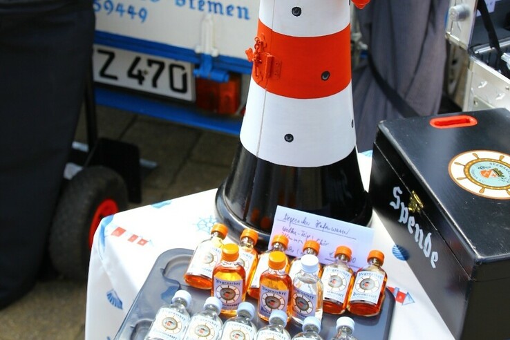 Model of a lighthouse with small bottles of liqueur on a table, decorated with maritime motifs.