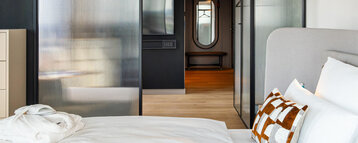 Blick vom Bett ins Zimmer mit Fernseher.