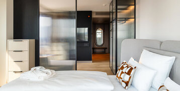 View from the bed into the room with the television.