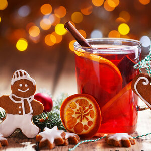 ATLANTIC Hotel Galopprennbahn Weihnachtlicher Tisch mit Glühwein, Zimtstange, Orangen, Lebkuchenmann und Lichterdekoration im Hintergrund.