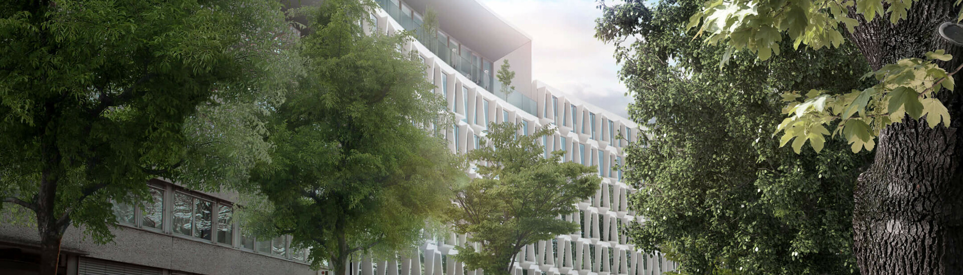 Moderne Fassade des ATLANTIC Hotels Münster, umgeben von Bäumen, mit vorbeifahrenden Autos auf der Straße.