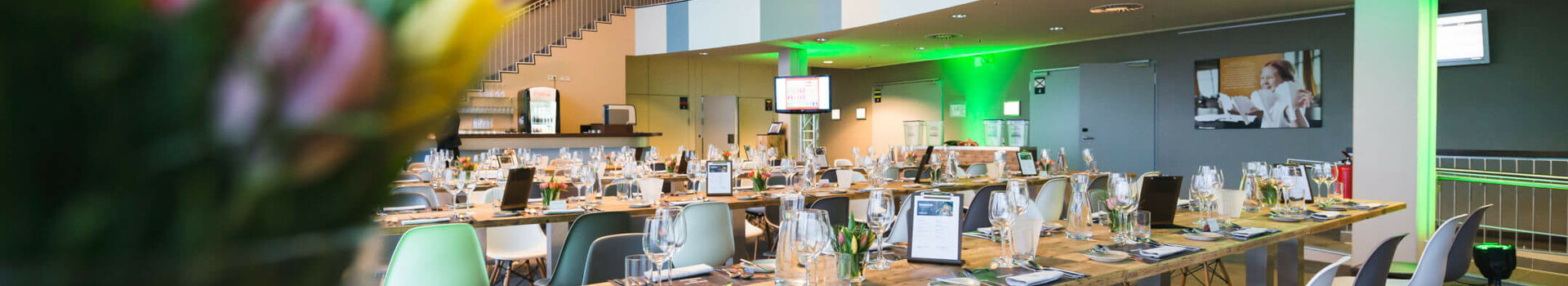 Festively set up tables for the 'Resteessen' (leftover dinner) at the ATLANTIC Hotel Sail City in Bremerhaven Modern restaurant in the ATLANTIC Hotel Sail City, Bremerhaven, with covered wooden tables and stylish lighting.