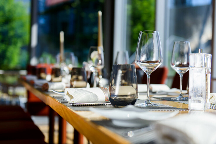 Eleganter, gedeckter Tisch im ATLANTIC Hotel Universum Bremen mit Weingläsern und Servietten.