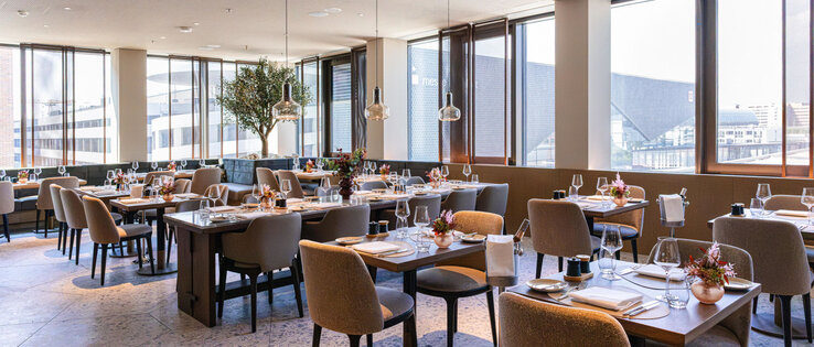 A bright, modern restaurant with a view of the Frankfurt Exhibition Centre.