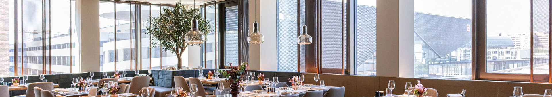 A bright, modern restaurant with a view of the Frankfurt Exhibition Centre.