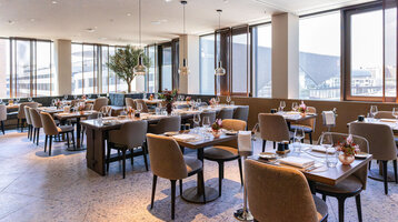 A bright, modern restaurant with a view of the Frankfurt Exhibition Centre.