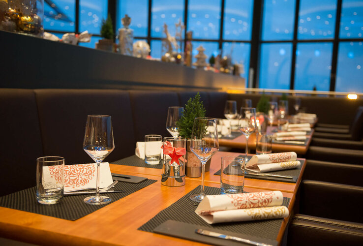 Festlich gedeckter Tisch im ATLANTIC Hotel Airport Bremen mit Gläsern, Besteck und dekorativen Servietten.