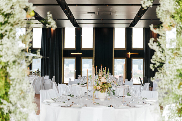 Elegant, festively decorated banquet hall in the ATLANTIC Hotel Heidelberg with flower arrangements and candles.
