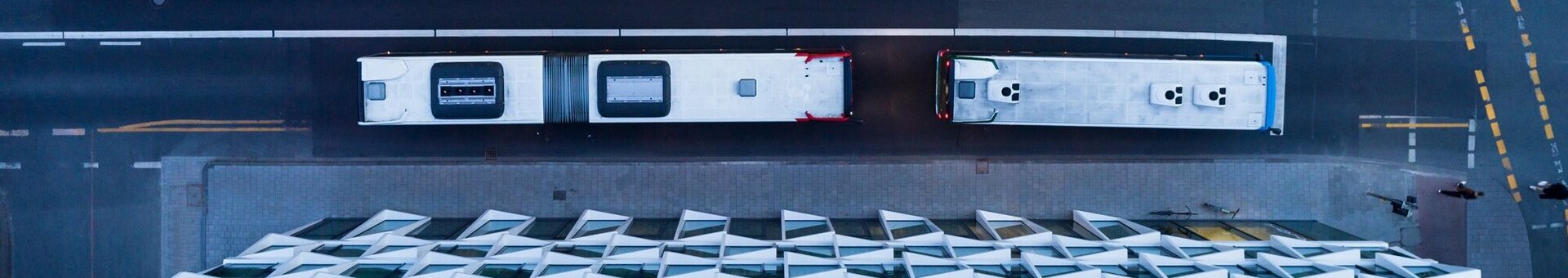 ATLANTIC Hotel Münster Lage und Anreise Straße Luftaufnahme des ATLANTIC Hotels Münster mit geometrischer Fassade, zwei Bussen auf der Straße und markierten Busspuren.