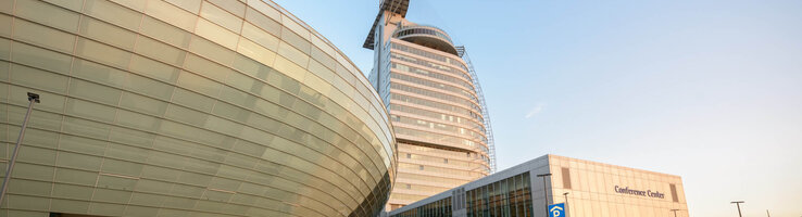 ATLANTIC Hotel Sail City in Bremerhaven, modern high-rise building with curved glass façade and adjoining conference center.