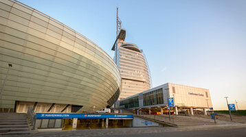 ATLANTIC Hotel Sail City in Bremerhaven, modern high-rise building with curved glass façade and adjoining conference center.