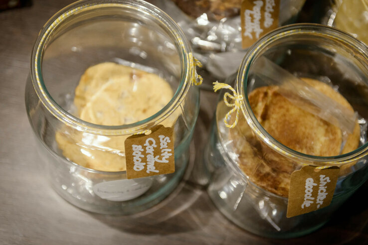Two glass jars with labeled labels, filled with cookies, on a table in the ATLANTIC Hotel Sail City.