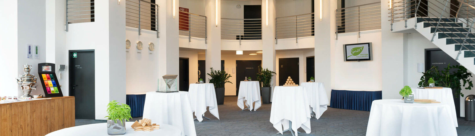 ATLANTIC Hotel Universum Foyer Moderner Veranstaltungsraum im ATLANTIC Hotel Universum, Bremen, mit Stehtischen und stilvoller Beleuchtung.