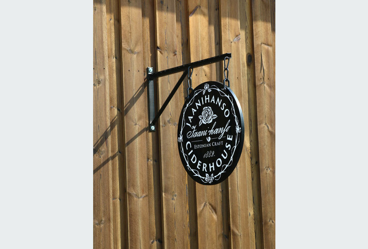 Black sign with white inscription "Jaanihanso Ciderhouse" attached to wooden wall.
