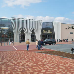 Weserpark Bremen Eingang des Weserparks mit modernem Glasdesign, Menschen und Autos auf dem Vorplatz bei sonnigem Wetter.