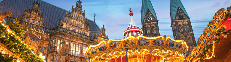 Bremer Weihnachtsmarkt mit Karussel und stilvoller Beleuchtung vor dunklem Himmel