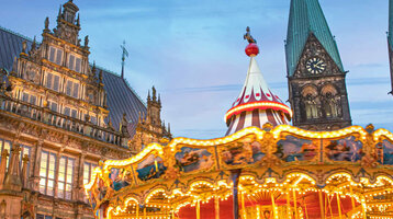 Bremer Weihnachtsmarkt mit Karussel und stilvoller Beleuchtung vor dunklem Himmel